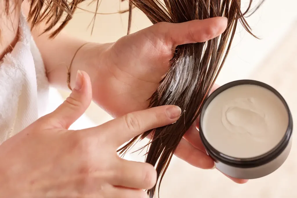 A woman applying hair treatment