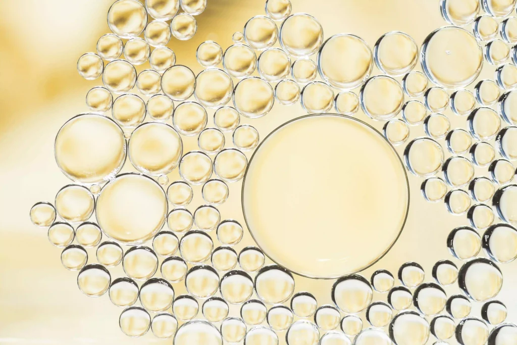 Golden microscopic bubbles representing the deep cleaning action of anti-dandruff ingredients.