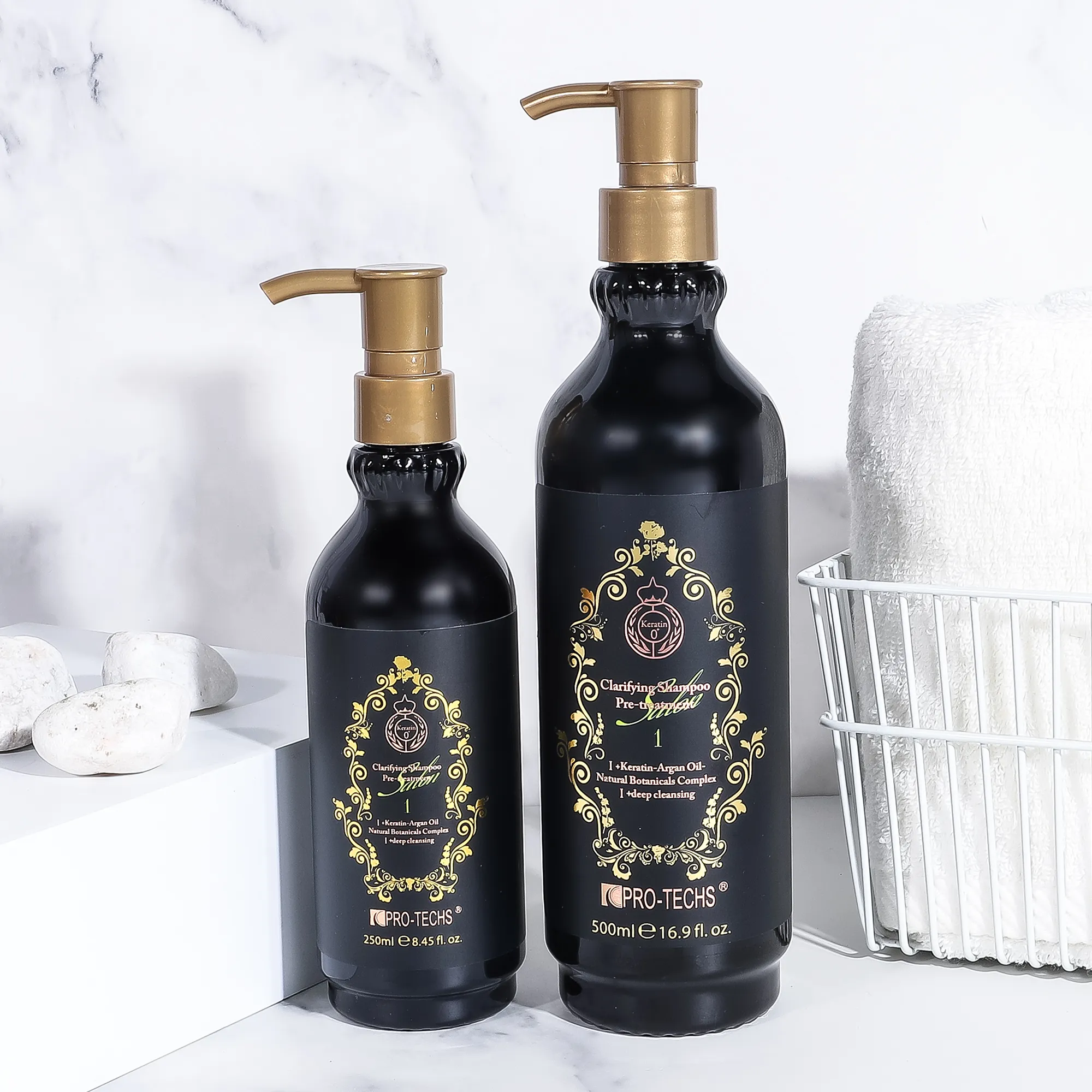 Two black pump bottles of Clarifying Shampoo No.1 (250ml and 500ml) with ornate gold labels, displayed on a marble surface next to white stones and a towel basket.