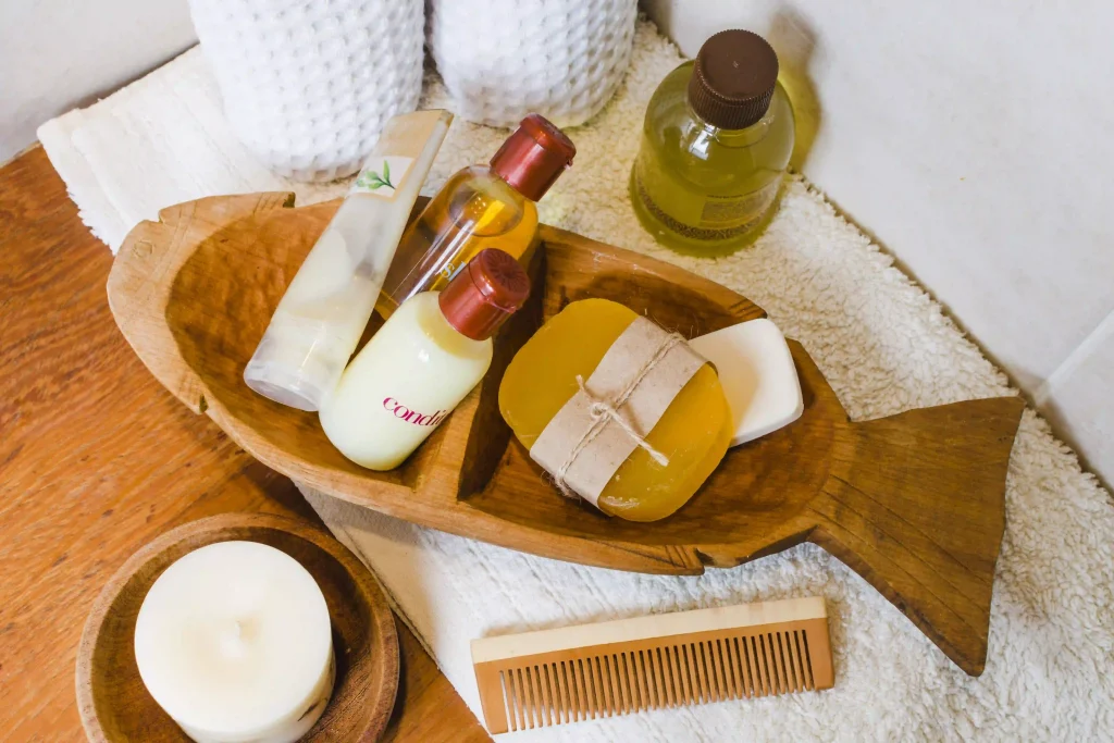 Variety of hair care products including oils, soaps, and a wooden comb in a fish-shaped tray.