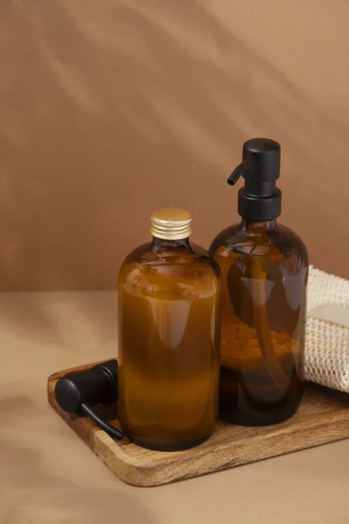Eco-friendly amber glass shampoo bottles with black pumps on a wooden tray, showcasing premium brand packaging.
