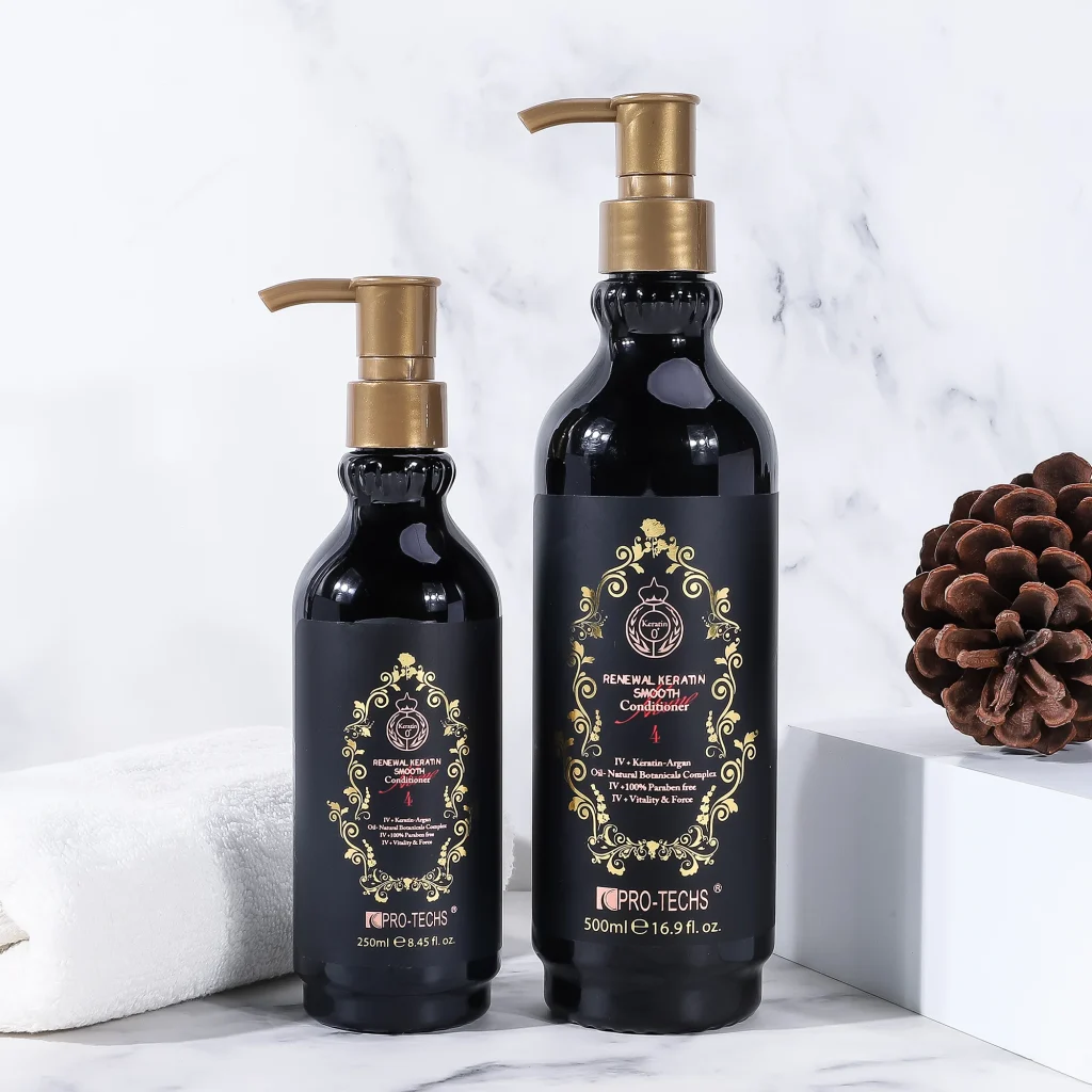 Two black bottles of "Renewal Keratin Smooth Conditioner 4" in 250ml and 500ml sizes with gold pump dispensers and ornate labels, displayed on a marble surface next to a white towel and a pinecone.