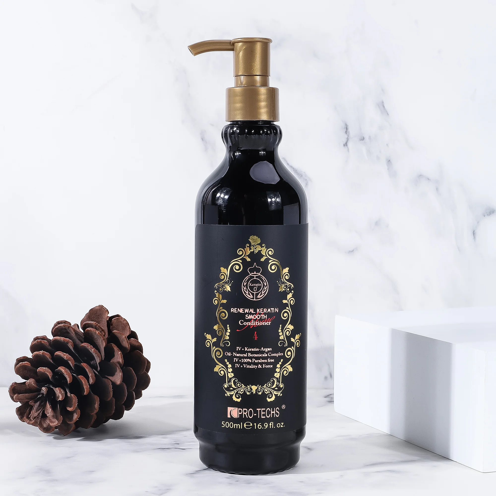 A 500ml black bottle of "Renewal Keratin Smooth Conditioner 4" with an ornate gold label and gold pump dispenser, styled on a marble surface next to a pinecone and a white decorative block.