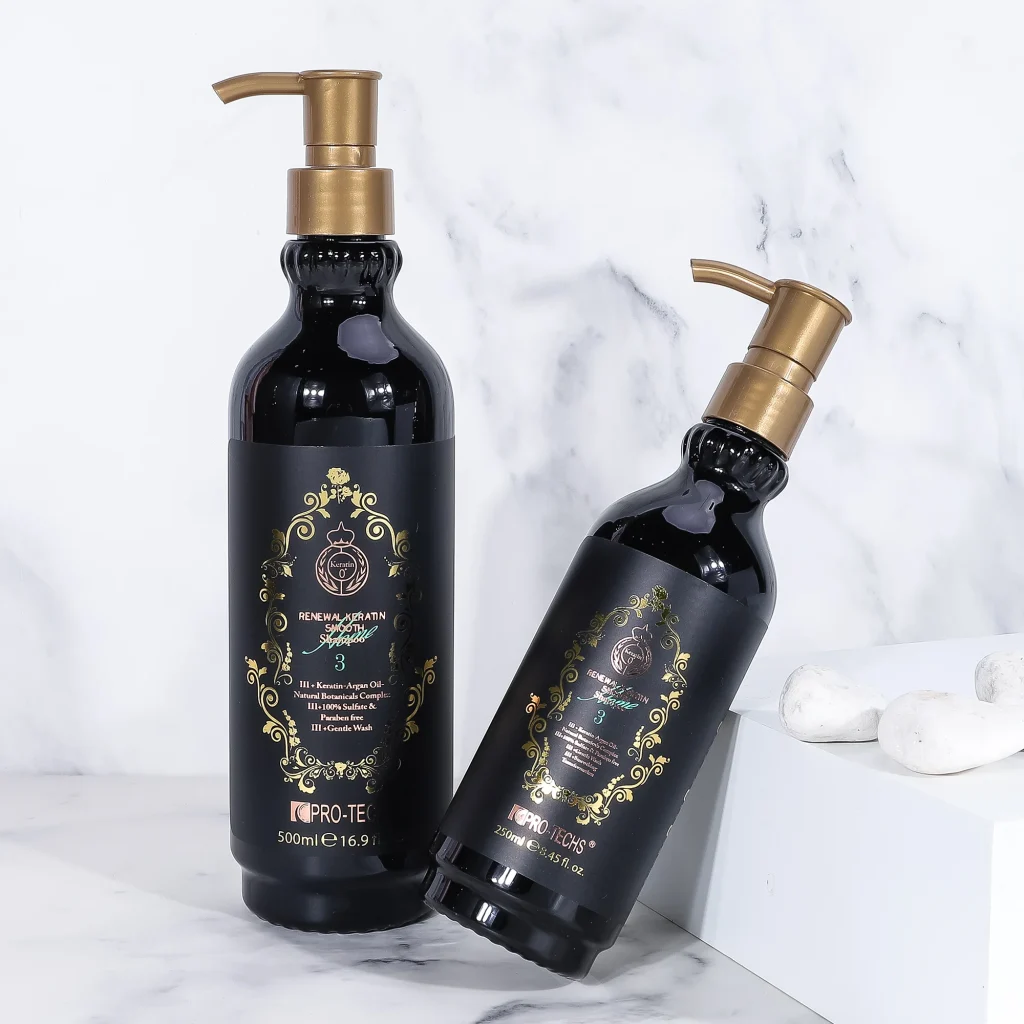 Two black bottles of "Renewal Keratin Smooth Shampoo 3" in 500ml and 250ml sizes with gold pump dispensers and ornate labels, styled on a marble surface with white decorative stones.