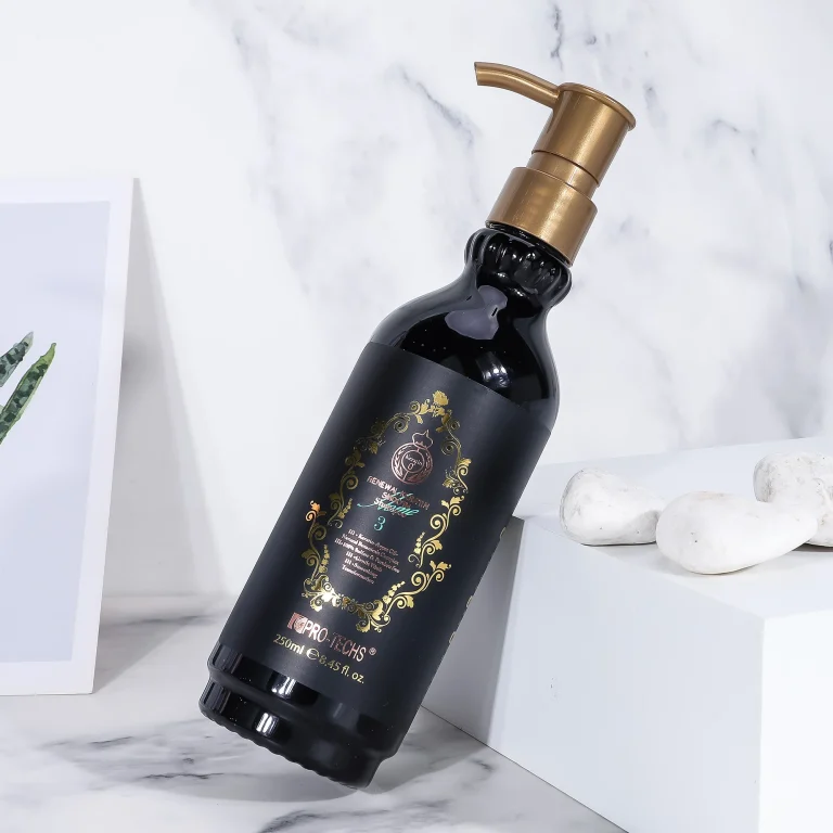 A sleek black 250ml bottle of "Renewal Keratin Smooth Shampoo 3" with an ornate gold label and gold pump dispenser, leaning against a white block on a marble surface with white decorative stones.