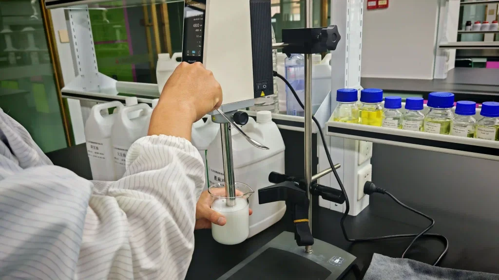 A digital viscometer and laboratory scale set up on a clean workbench for product consistency testing.
