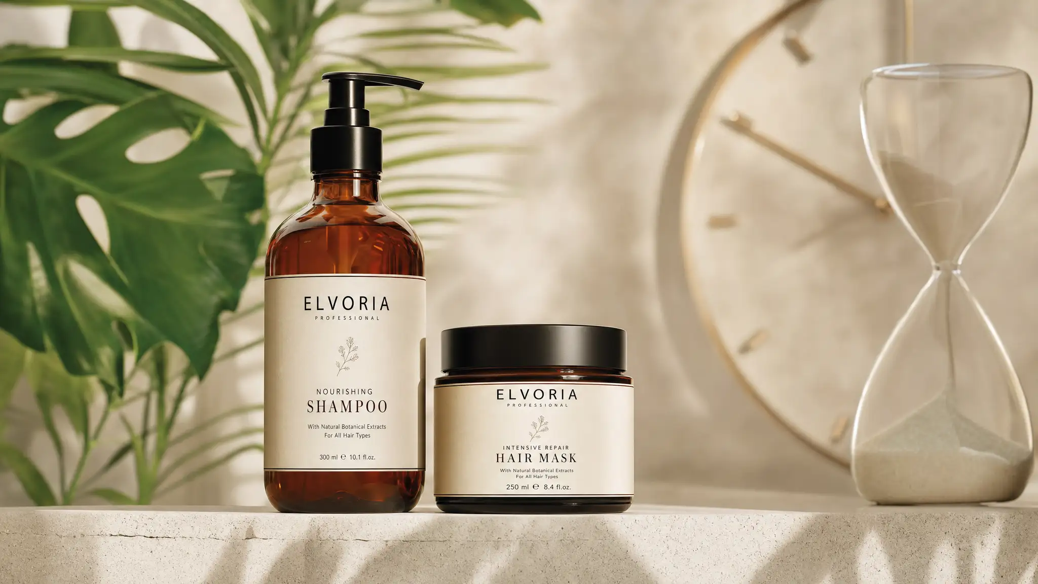 Elvoria professional nourishing shampoo and intensive repair hair mask on a light countertop with green plant leaves in the background and a glass hourglass to the right.