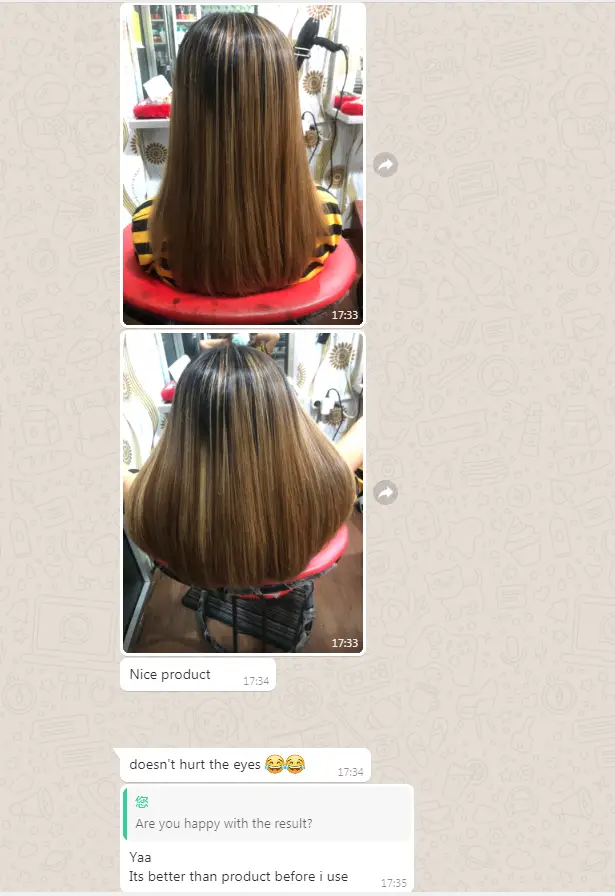 Rear view of a person seated in a salon chair with shoulder-length straight hair, light brown with blonde highlights in a bright salon setting.