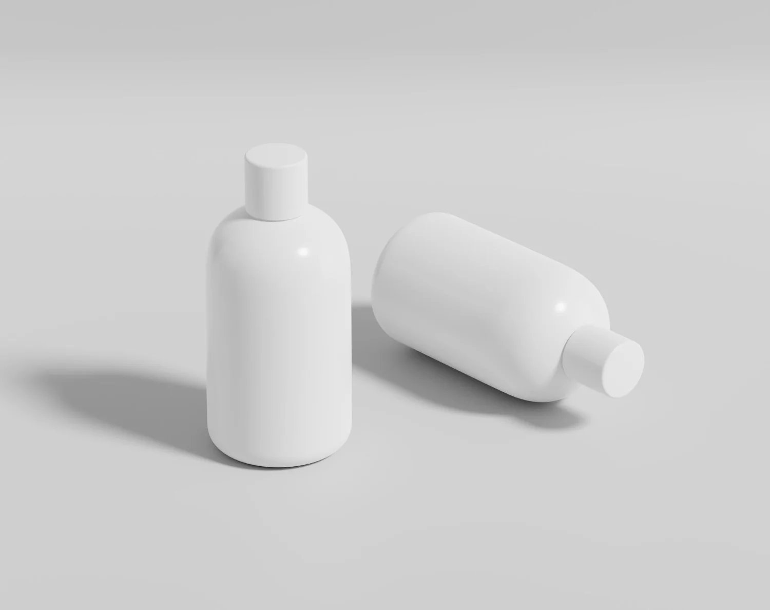 Two white cosmetic bottles on a gray surface, one upright and the other lying on its side.