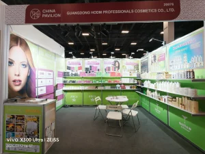 Cosmetics trade show booth with green display panels, product shelves, and seating under a China Pavilion sign.