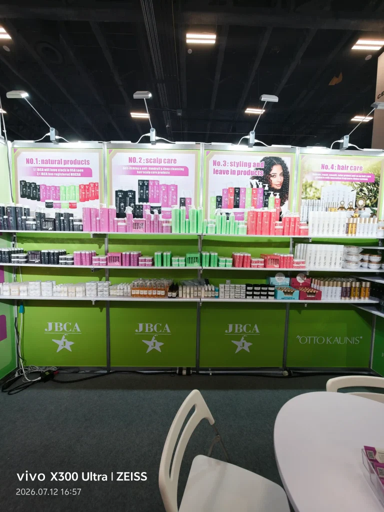 Colorful hair care products arranged on a booth with labeled banners reading No.1 natural products, No.2 scalp care, and No.3 styling and leave-in products.
