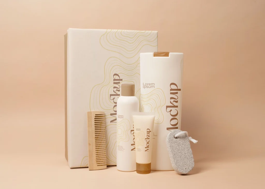Display of grooming products: white bottles, a wooden comb, a pumice stone, and a decorative box with gold wavy patterns on a peach background.