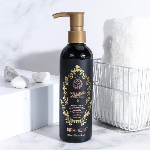 A 250ml black bottle of "Renewal Keratin Smooth Detangling Cream 5" featuring a gold pump and an ornate gold label, displayed on a marble surface next to a white basket containing a rolled towel.